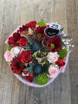 Bloemstukje rond rode en roze tinten