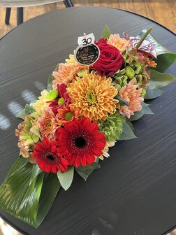 Bloemstukje Allerheiligen rode en oranje tinten smal