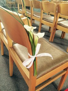 Stoeldecoratie 2 calla's met beregras en strik