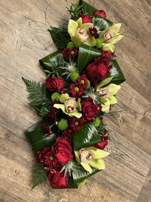 Bloemstuk Allerheiligen rode en groene tinten orchidee